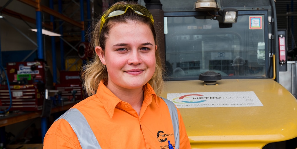 Portrait of Jodie a female apprentice in hi vis vest smiling